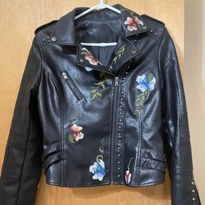 Floral embroidery, stud accents, buckles on side, faux leather, zipper on arms.